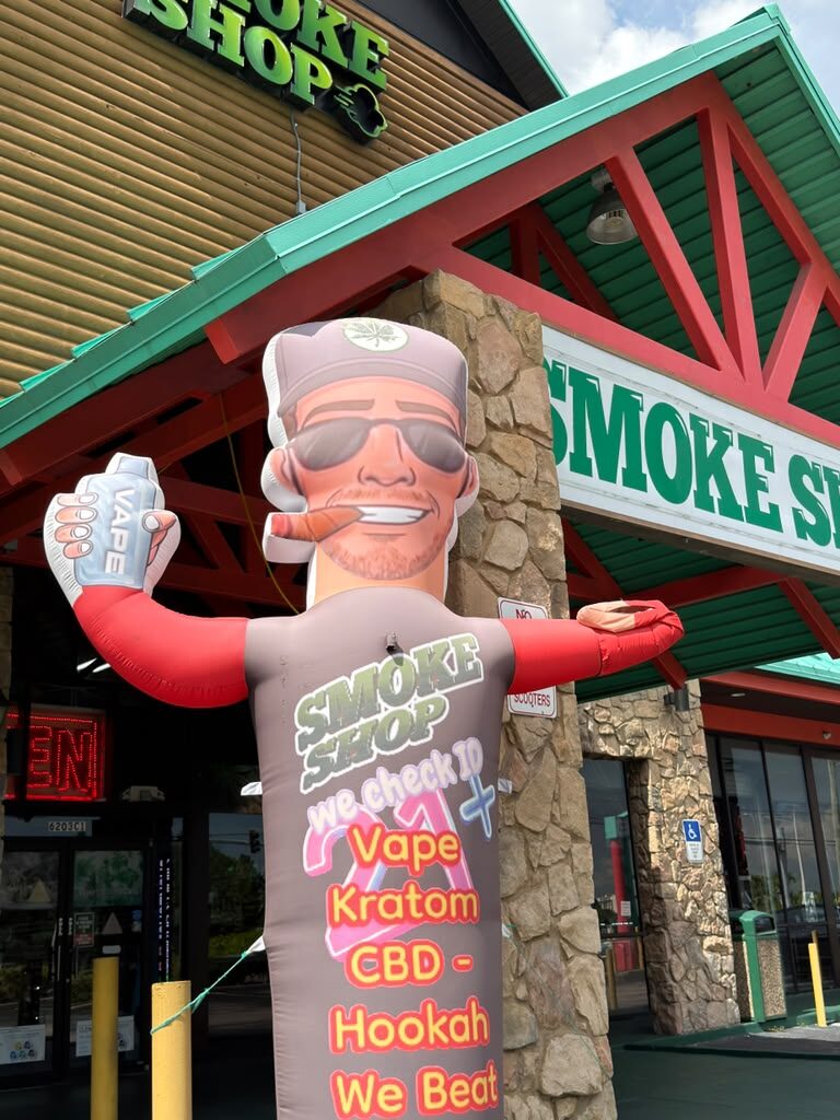 Inflatable tube figure outside the 247 Smoke Shop entrance on W Sand Lake Rd in Orlando