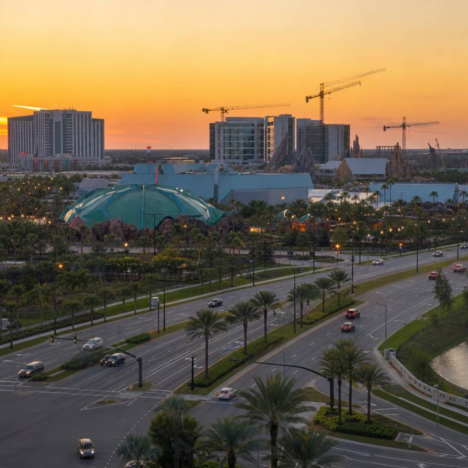 New theme park area near Kirkman Road in Orlando at golden hour with hotel towers on the horizon.