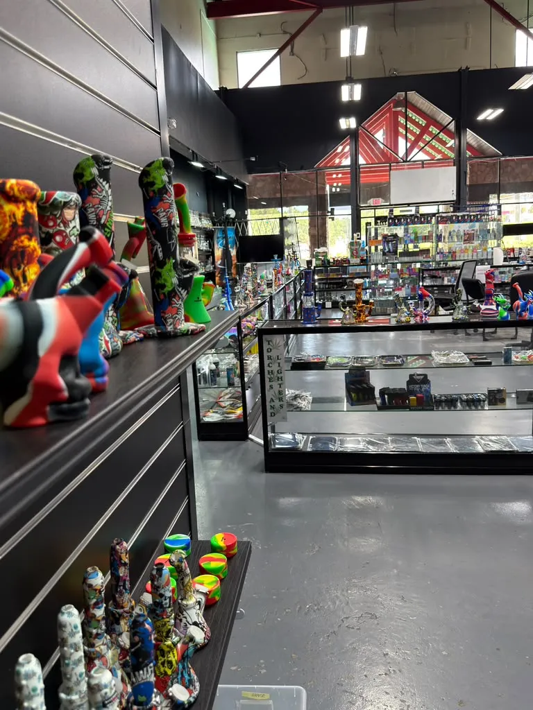 Glass and colorful accessories arranged in illuminated display cases inside 247 Smoke Shop.