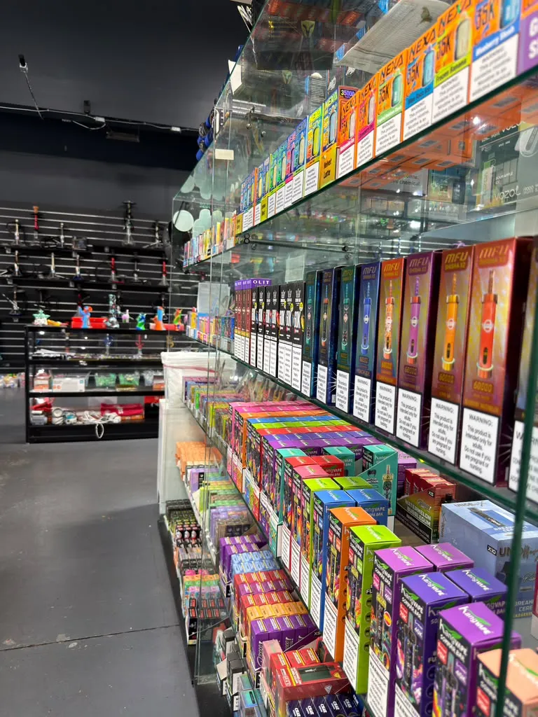 The real vape wall inside 247 Smoke Shop on Sand Lake Road — disposable vapes from Geek Bar, RAZ, Lost Mary and more