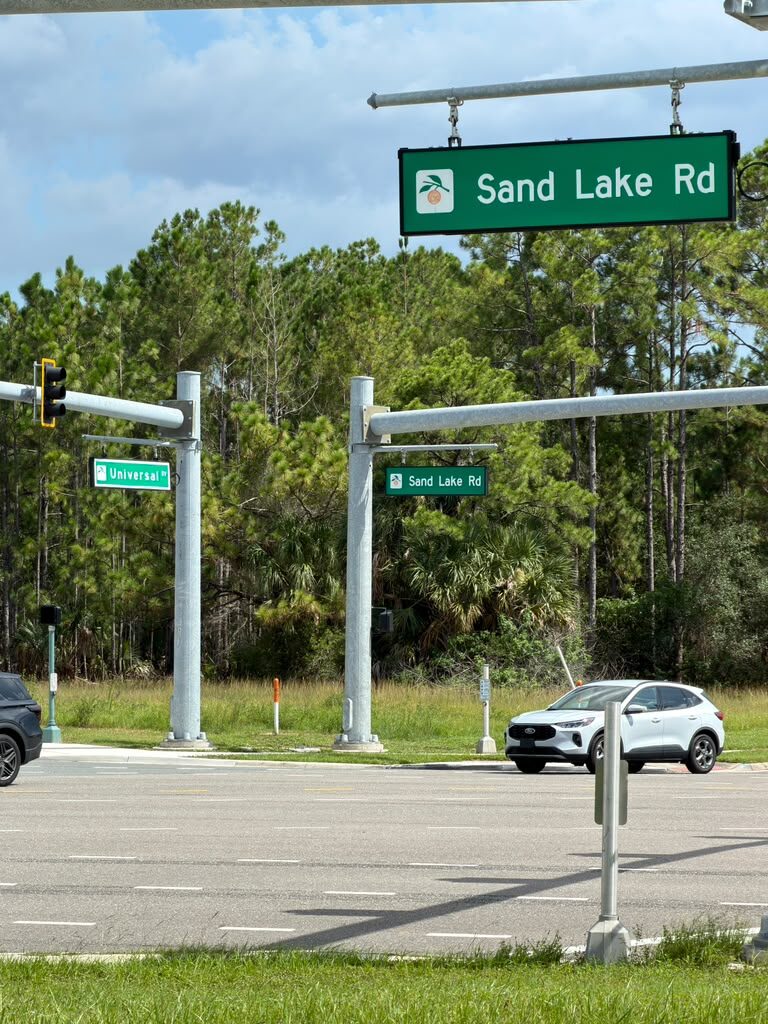 Sand Lake Rd and Universal Blvd street signs at the traffic signal near 247 Smoke Shop in Orlando
