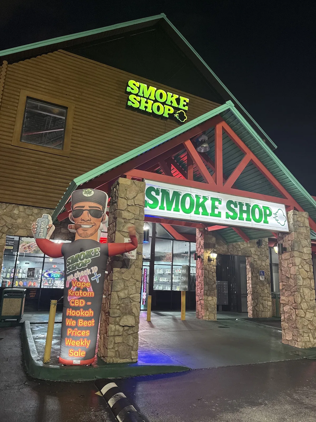 247 Smoke Shop storefront at night on West Sand Lake Road near Universal Boulevard.