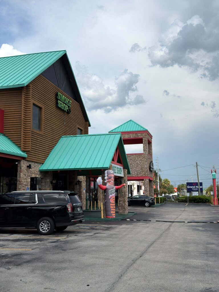 247 Smoke Shop building and free parking lot on W Sand Lake Rd in Orlando
