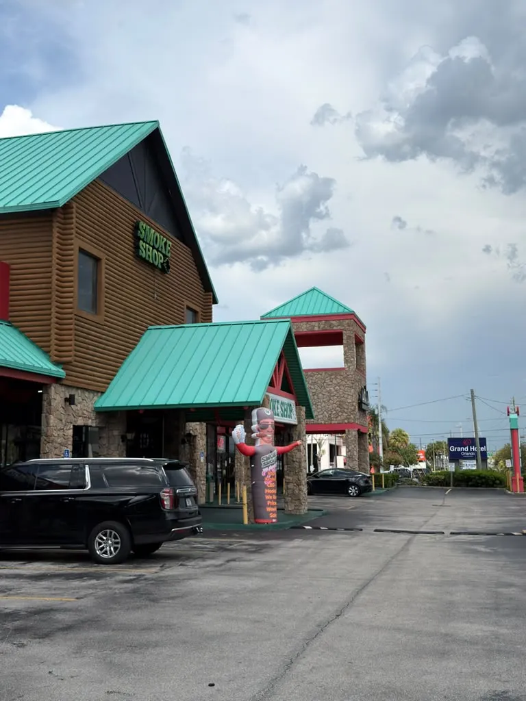 247 Smoke Shop building and free parking lot on W Sand Lake Rd in Orlando